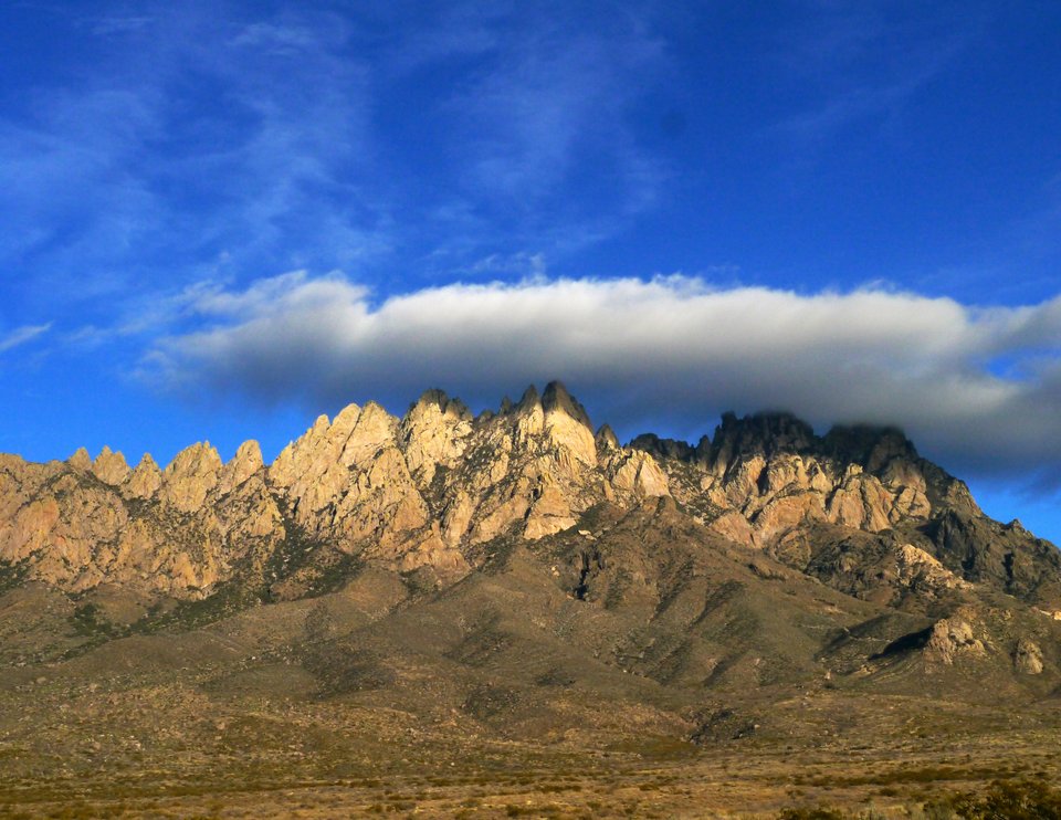 view of the Organ Mountains topped by a large cloud