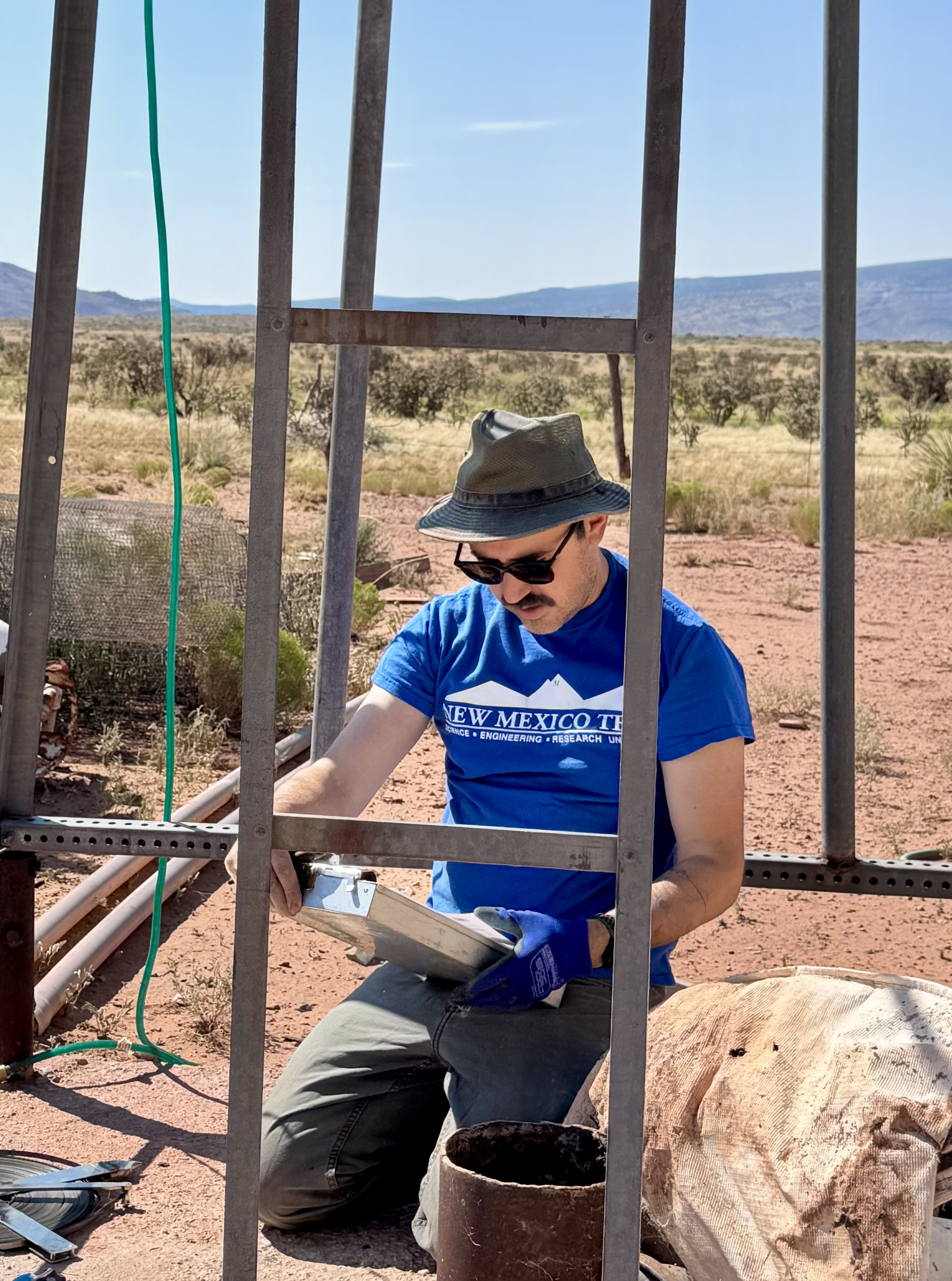 Field hydrogeologist collecting groundwater level measurements at a domestic well